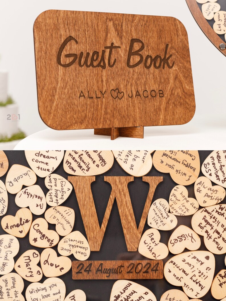 May include: A wooden guest book with the words "Guest Book" and "ALLY JACOB" engraved on it. The book is decorated with a wooden letter "W" and a date "24 August 2024". The letter "W" is surrounded by small wooden hearts with handwritten messages.