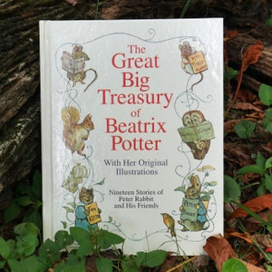 Peut inclure: Un livre blanc avec un titre rouge, "The Great Big Treasury of Beatrix Potter", illustrant des personnages des histoires de Beatrix Potter, notamment Peter Rabbit, Squirrel Nutkin et Tom Kitten.
