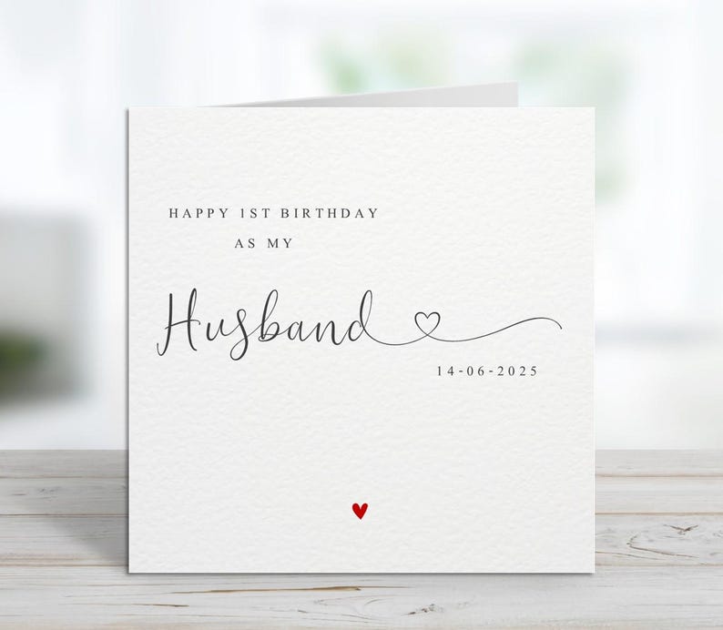 Może przedstawiać: Biała kartka z napisem "HAPPY 1ST BIRTHDAY AS MY Husband" czcionką w kolorze czarnym. Małe czerwone serce na dole i data "14-06-2025" pod słowem "Husband".