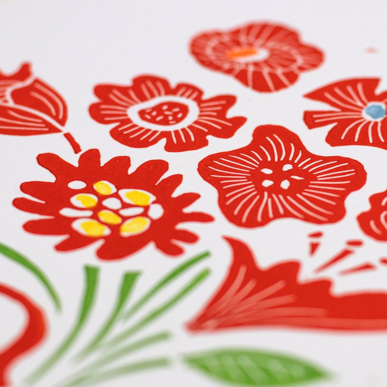 May include: A white background with a red floral pattern. The flowers are stylized and have a simple design. The flowers are red with white outlines and some have yellow centers.