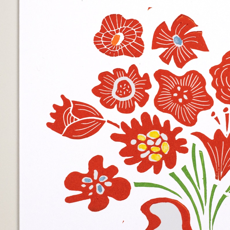 May include: A red and green floral print with a white background. The flowers are stylized and have a folk art feel. The print is perfect for a variety of projects, including fabric, paper, and home decor.