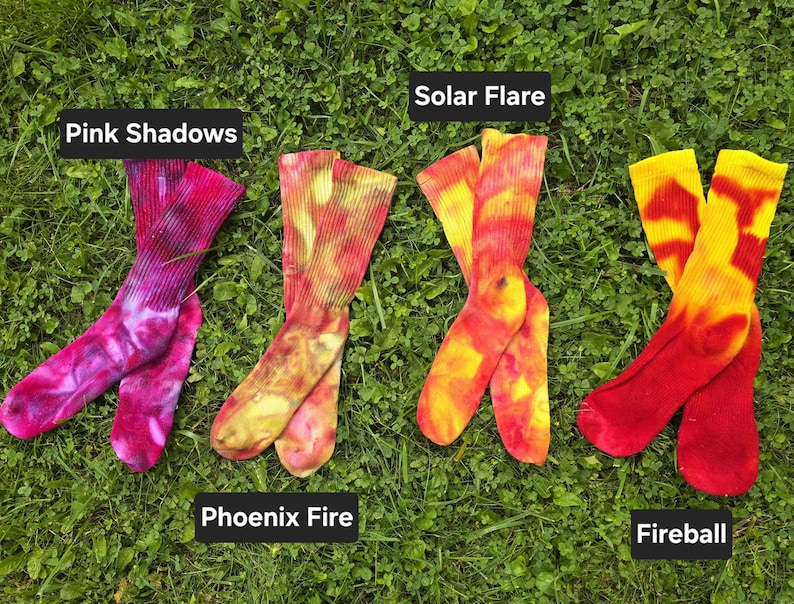 Peut inclure: Quatre paires de chaussettes montantes tie-dye avec des motifs de couleurs distincts &eacute;tiquet&eacute;s Pink Shadows en magenta et violet, Phoenix Fire en orange et jaune, Solar Flare en jaune et orange, et Fireball en rouge vif et jaune.