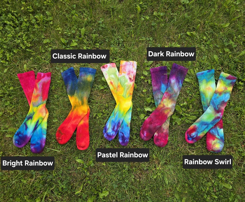 Peut inclure: Cinq paires de chaussettes montantes tie-dye dispos&eacute;es en rang&eacute;e. Les &eacute;tiquettes identifient les motifs de couleurs comme Bright Rainbow, Classic Rainbow, Pastel Rainbow, Dark Rainbow et Rainbow Swirl. Chaque paire pr&eacute;sente un m&eacute;lange unique.