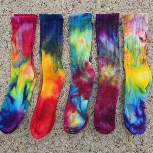 Peut inclure: Cinq paires de chaussettes mi-mollet avec des motifs tie-dye vibrants dans diverses combinaisons de couleurs, notamment rose, jaune, bleu, vert et violet. Chaque chaussette pr&eacute;sente un bord-c&ocirc;te et un tissu textur&eacute; aux motifs tourbillonnants.