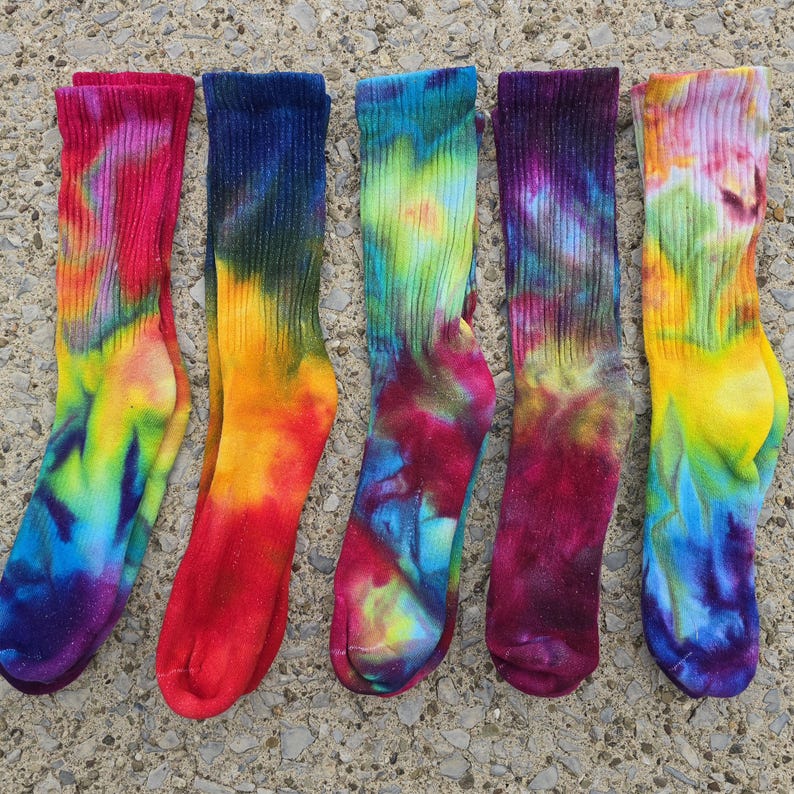 Peut inclure: Cinq paires de chaussettes mi-mollet avec des motifs tie-dye vibrants dans diverses combinaisons de couleurs, notamment rose, jaune, bleu, vert et violet. Chaque chaussette pr&eacute;sente un bord-c&ocirc;te et un tissu textur&eacute; aux motifs tourbillonnants.