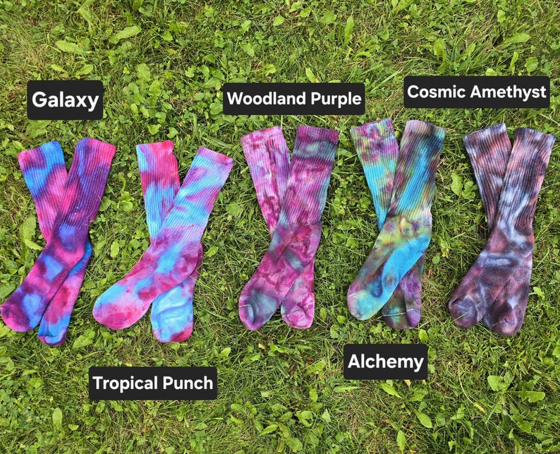 Peut inclure: Cinq paires de chaussettes montantes tie-dye dispos&eacute;es en rang&eacute;e. Les paires sont &eacute;tiquet&eacute;es Galaxy, Tropical Punch, Woodland Purple, Alchemy et Cosmic Amethyst. Chaque paire pr&eacute;sente un m&eacute;lange unique de couleurs vives, dont rose, bleu, violet et vert.