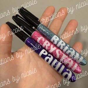 May include: A white ceramic mug with a black handle and the text "But First, Coffee" in a black, bold font. The mug is on a white surface.