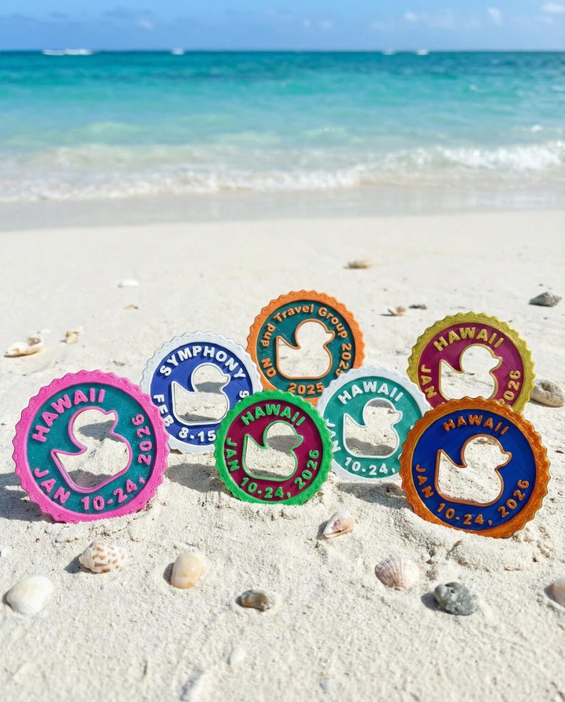 May include: Seven circular plastic tags with scalloped edges, each featuring a central duck cutout. The tags display various colors including pink, blue, orange, green, and yellow, with printed text such as HAWAII, SYMPHONY, and dates like JAN 10-24, 2026.
