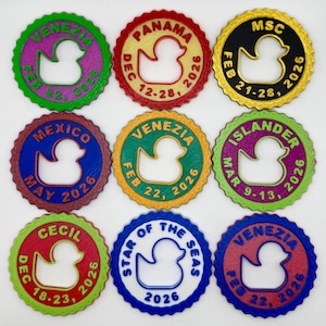 May include: Nine circular, scalloped-edge tags featuring a central rubber duck cutout. Each tag displays unique text including locations like VENEZIA, PANAMA, MSC, MEXICO, ISLANDER, CECIL, and STAR OF THE SEAS, alongside various dates in 2026 in vibrant colors.