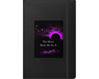 Könnte beinhalten: Schwarzes Notizbuch mit einem lila und schwarzen Bild eines Halbmondes mit Sternen und dem Text "The Moon Made Me Do It".