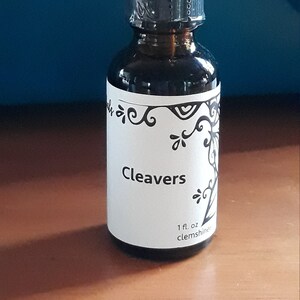 May include: A small brown glass bottle with a black dropper top. The bottle has a white label with black text that reads "Cleavers 1 fl. oz clemshine".