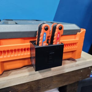 May include: A black plastic tool holder with two red and black multi-tool wrenches. The wrenches are labeled "SAE" and "METRIC".