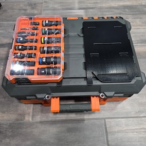 May include: A black and orange tool box with a clear lid containing various sockets. The toolbox has a handle and a black top with a hinged cover. The sockets are in various sizes and colors.