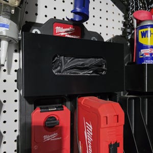 May include: Black Milwaukee Packout storage system with red accents, mounted on a pegboard. Includes a black box with a cutout, and red Packout containers. A blue tool is mounted above the box.