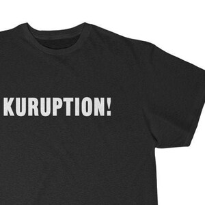 May include: A black t-shirt with the word "KURUPTION!" printed in white on the front.
