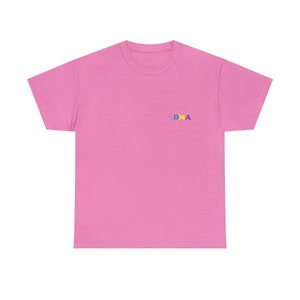 Op de afbeelding: Roze T-shirt met korte mouwen met het woord "DMA" geborduurd op de borst in kleurrijke letters.