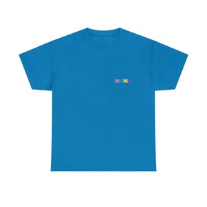Op de afbeelding: Een felblauw t-shirt met het woord "MOMA" geborduurd op de voorkant in kleurrijke letters.