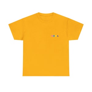 Op de afbeelding: Een geel T-shirt met korte mouwen met het woord "MDMA" geborduurd op de borst in regenboogkleuren.