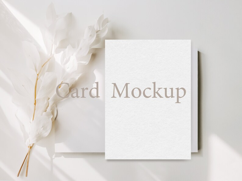 May include: A white card mockup with the text "Card Mockup" on a white background with a white branch with dried leaves.