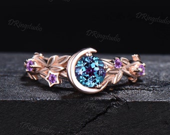 May include: A rose gold ring with a crescent moon design and a blue and purple gemstone. The ring is adorned with small purple gemstones and star-shaped accents.