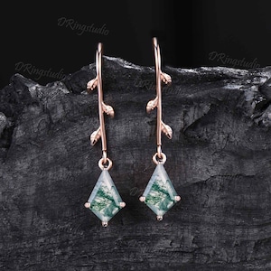 May include: Rose gold earrings with a green agate stone and a delicate branch design.