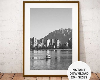 May include: A black and white photograph of a city skyline with a ferry boat in the foreground. The city is situated on the waterfront with mountains in the background.