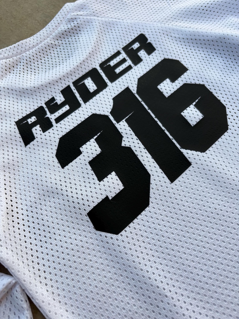 K&ouml;nnte beinhalten: Wei&szlig;es Mesh-Trikot mit schwarzem Text "Ryder 316".