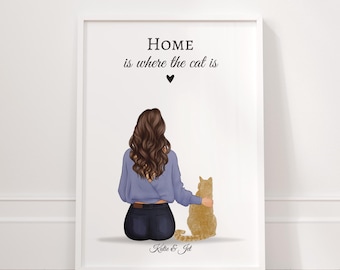 May include: Framed art print featuring a woman and a cat. The illustration shows a woman in a blue shirt and dark jeans, seated next to a ginger cat. The text "HOME is where the cat is" is above the figures.