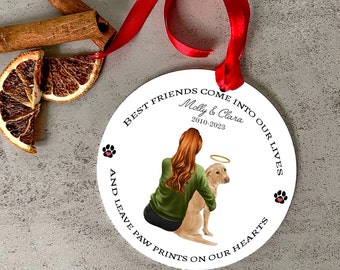 May include: White round ornament with a green and brown illustration of a woman holding a dog. The text reads "Best friends come into our lives and leave paw prints on our hearts."  The names "Molly & Clara" and the dates "2010-2023" are also included.
