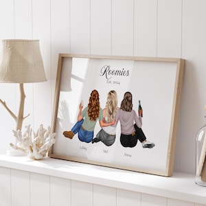 May include: A framed illustration of three friends, with the text "Roomies Est. 2024" at the top. The friends are depicted from the back, with their names "Libby", "Mel", and "Anna" written below them.