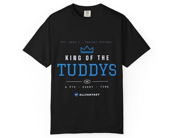 Puede incluir: Una camiseta negra de manga corta con un estampado gráfico en azul y blanco. El texto dice EST. WEEK 1 - FANTASY FOOTBALL, KING OF THE TUDDYS, 6 PTS - EVERY - TIME y ALLFANTASY, junto a un icono de corona y un icono de balón.