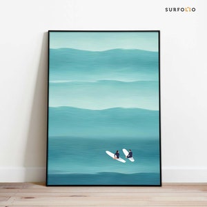 May include: A framed abstract painting of two figures on surfboards in a teal ocean. The painting has a minimalist style and features a light blue and teal color palette.