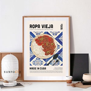 May include: A framed poster featuring a Cuban Ropa Vieja dish illustration. The artwork showcases a plate of shredded beef, rice, and vegetables on a blue and white tile background. Text includes "ROPA VIEJA" and "MADE IN CUBA".