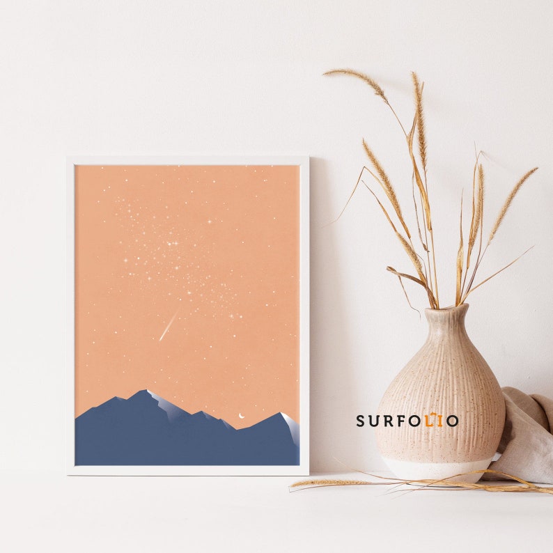 Pode incluir: Uma impress&atilde;o emoldurada com um design minimalista que apresenta um c&eacute;u cor de p&ecirc;ssego com estrelas brancas e uma estrela cadente, uma lua crescente e uma silhueta de montanhas azuis.