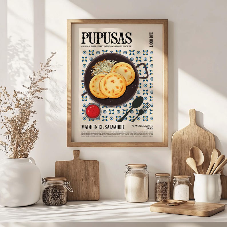 May include: A framed poster featuring a culinary illustration of pupusas, a Salvadoran dish. The poster includes the text "PUPUSAS" and "MADE IN EL SALVADOR". The image shows three pupusas on a plate, with a side of sauce and a decorative pattern.