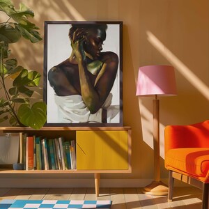 May include: A framed artwork featuring a portrait of a person with dark skin, draped in white fabric. The artwork is displayed on a mid-century modern style cabinet with a yellow door. A pink lamp and orange chair are also in the room.