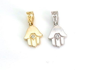 May include: Two hamsa hand charms with a small diamond in the center. One charm is gold and the other is silver.