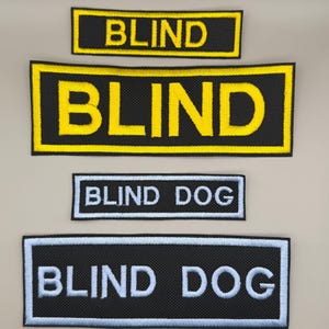 May include: Four rectangular embroidered patches. Two patches feature the word BLIND in yellow thread on a black background with yellow borders. Two patches feature the text BLIND DOG in white thread on a black background with light blue borders.