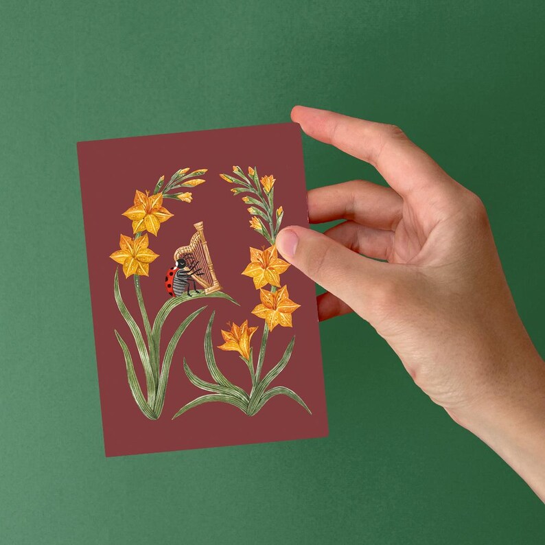 K&ouml;nnte beinhalten: Ein roter Marienk&auml;fer spielt auf einer Harfe, umgeben von gelben Blumen auf einem burgunderroten Hintergrund.