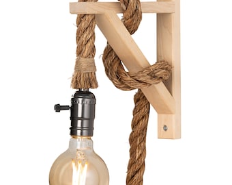 May include: A wooden wall sconce with a rope cord and a light bulb. The rope is tied in a knot and the sconce is mounted on a wall.