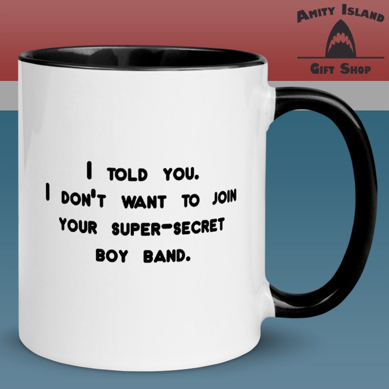 May include: White ceramic mug with a black rim and handle. The mug has black text that reads "I TOLD YOU. I DON'T WANT TO JOIN YOUR SUPER-SECRET BOY BAND."