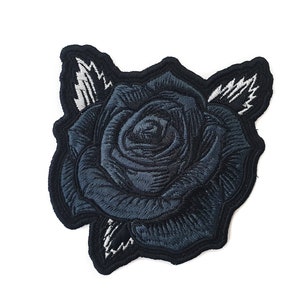 May include: Embroidered patch of a dark blue rose with black edging and white leaf detailing. The floral design is intricately stitched, ideal for application on garments or accessories.