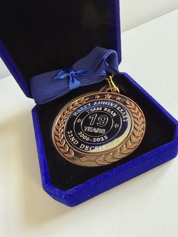A real physical medal — like an Olympic gold — custom engraved with your anniversary year and names, presented in a velvet box; subverts the usual 'framed print' anniversary gift trope in a genuinely fun way.