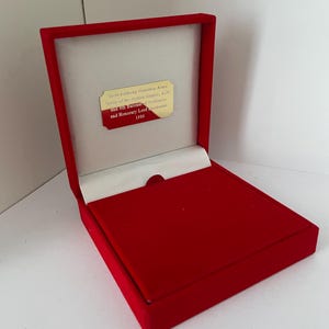 May include: A red velvet box with a gold plaque inside. The plaque reads "Sir Anthony Francis Abell, Knight of the British Empire, K.B.E. and 8th Baronet, Lord Lieutenant and Honorary Lord 1989."