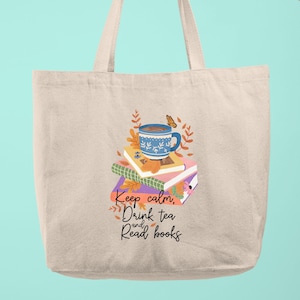 May include: A beige tote bag with a design of a blue teacup with a butterfly on a stack of books. The text "Keep calm, Drink tea and Read books" is printed on the bag.