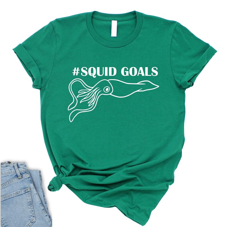 A green t-shirt with a white graphic of an octopus and the text "#SQUID GOALS" printed on it.