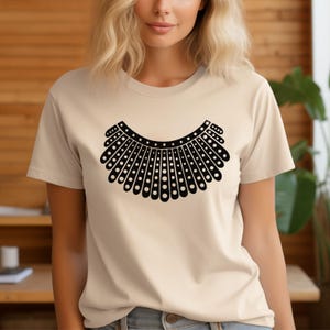 A woman wearing a white t-shirt with a black graphic design on it.