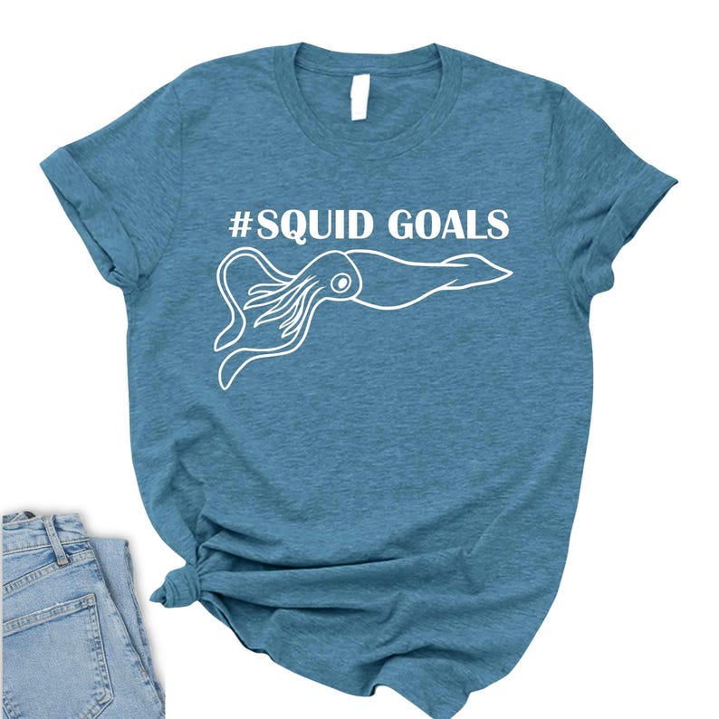 A blue t-shirt with a white graphic of an octopus and the text "#SQUID GOALS" printed on it.