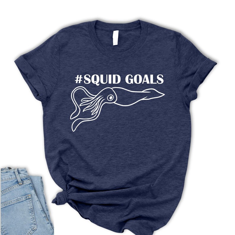 A navy blue t-shirt with a white graphic of an octopus and the text "#SQUID GOALS" printed on it.