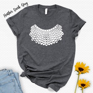 a gray t-shirt with a white graphic design, a pair of blue jeans, and two yellow sunflowers.